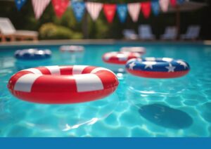 Red, white, and blue patriotic pool floats in a swimming pool decorated with American flag bunting, set for a July 4th celebration
