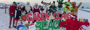 Runners in Santa hats participating in the Sandy Claws Beach Run on Siesta Beach.