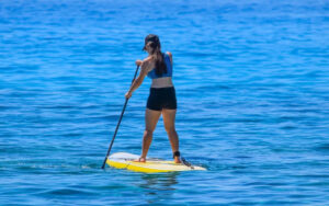 Solo traveler paddleboarding on calm blue waters near Siesta Key, enjoying a peaceful day on the Gulf.