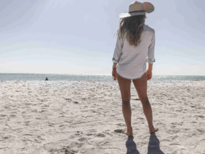 Solo traveler standing on the shoreline at Siesta Key Beach on a sunny day, enjoying a quiet beach escape.