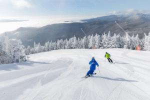 Downhill skiing in Vermont with snow-covered trees and mountain views