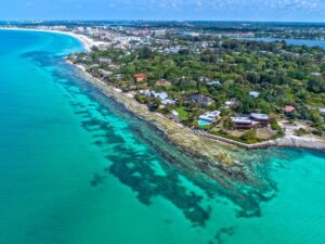 Aerial view of Point of Rocks on Siesta Key with turquoise Gulf of Mexico water and coastal homes along the shoreline in Sarasota, Florida.