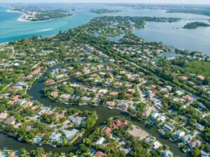 Aerial view of Siesta Key showing a network of winding residential canals, waterfront homes, and access to Sarasota Bay and the Gulf of Mexico