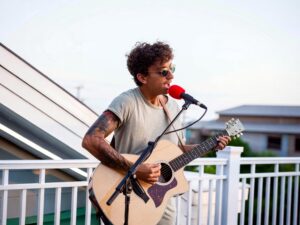 Acoustic singer-songwriter performing live at Daiquiri Deck in Siesta Key, Florida, creating a lively atmosphere for guests enjoying food, drinks, and island entertainment.