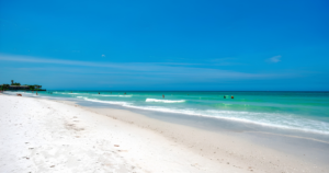 Crescent Beach on Siesta Key, Florida, with white quartz sand and turquoise Gulf waters under a clear blue sky.