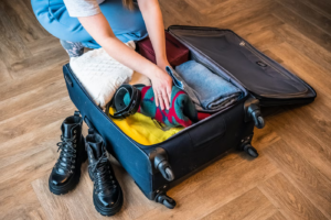Traveler packing clothes and essentials into a suitcase for a Siesta Key vacation